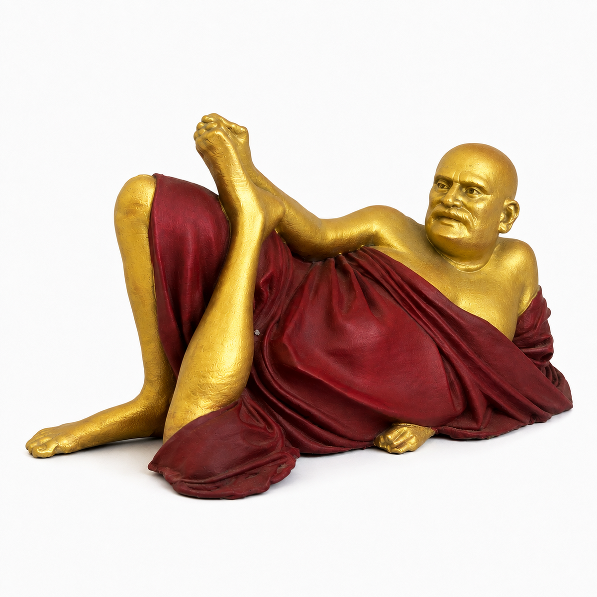 Neem Karoli Baba reclining statue in gold and maroon on white background